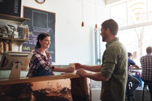 small business and local restaurant worker serving coffee to customer